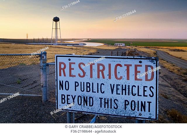 Restricted Access sign along the California Aquaduct at sunset in the Central Valley, near Los Bano, Merced County, California