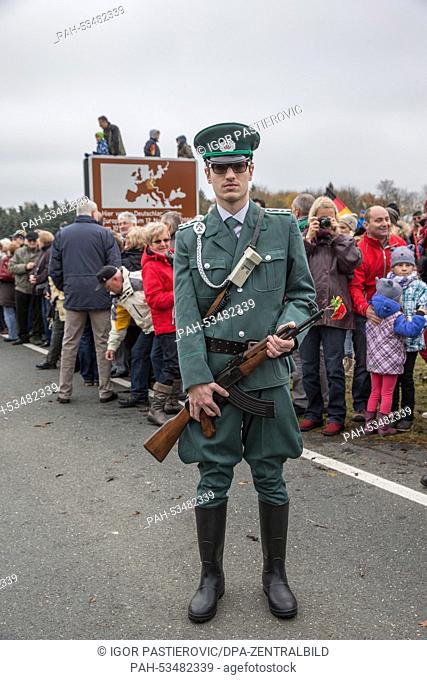 An actor in the uniform of a border soldier from East Germany poses with his rifle at the former border Grossing in Ullitz, Germany, 9 November 2014