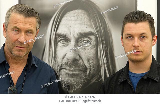 Photographers Andreas Neumann (L) and Matt Helders pose in front of a photo of Iggy Pop during the opening of the exhibition 'American Valhalla: The Art of...