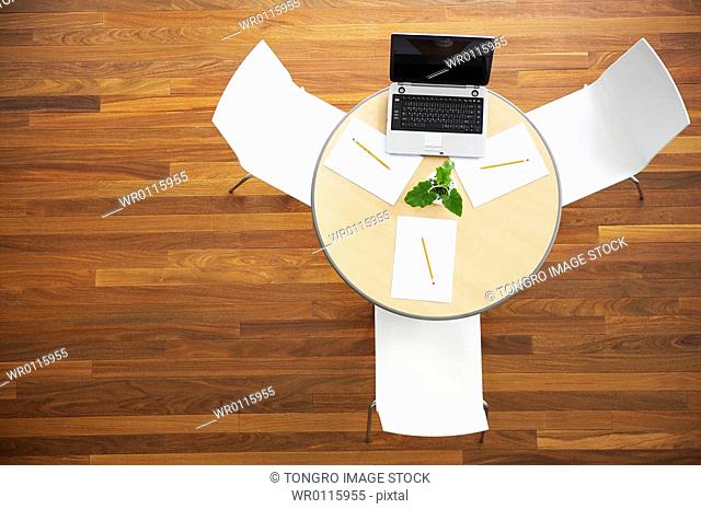 notebook on the round table and chiar at high angle