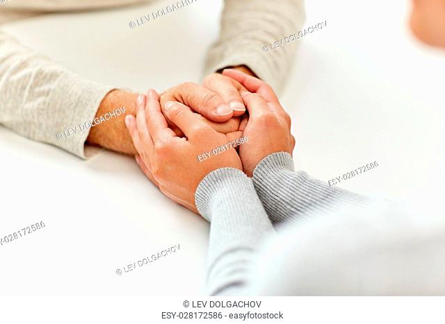 old age, support, charity, care and people concept - close up of senior man and young woman holding hands