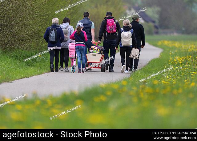 01 May 2023, Baden-Württemberg, Unlingen: Two families are on a hiking trail with a handcart on May Day. Photo: Thomas Warnack/dpa