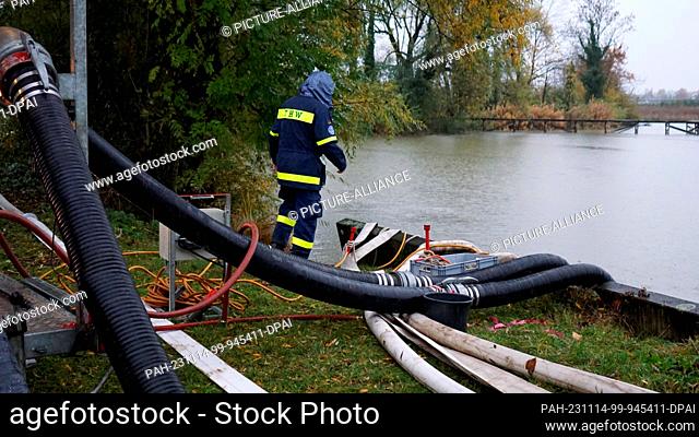 14 November 2023, Baden-Württemberg, Friedrichshafen: A helper from the Federal Agency for Technical Relief (THW) stands by a pond