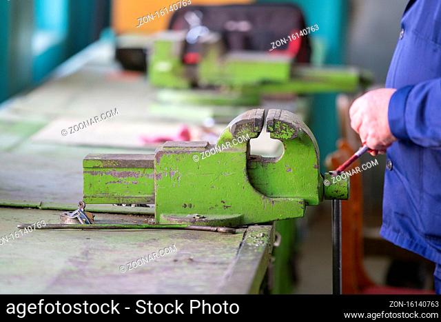 Working hands at the vise. Working locksmith