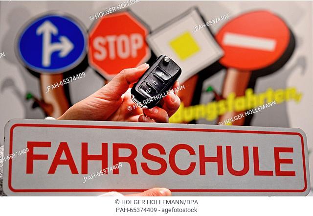 ILLUSTRATION - A driving school sign with car keys and road signs in the background at a driving school in Langenhagen, Germany, 26 January 2016