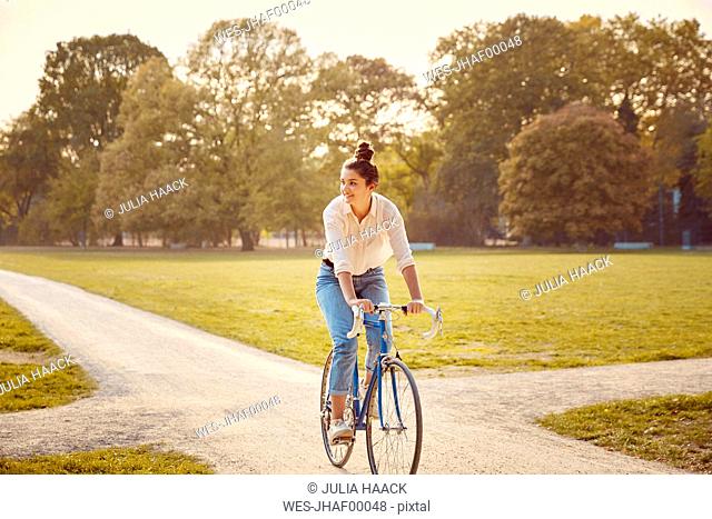Young woman riding bike at a park