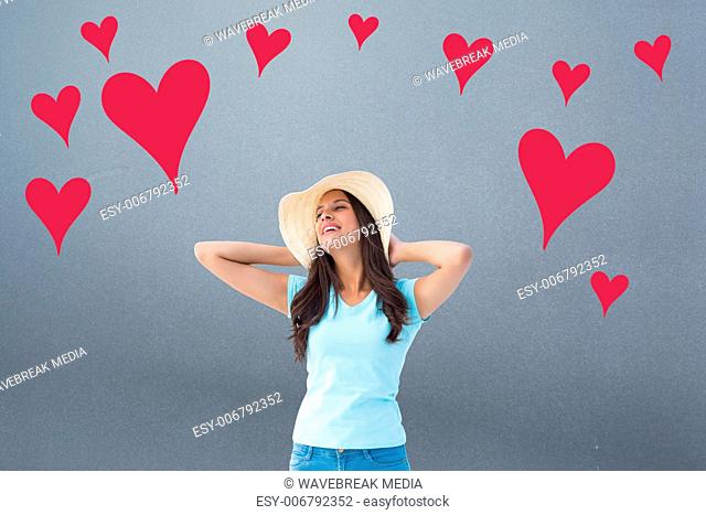 Composite image of happy young brunette wearing sunhat