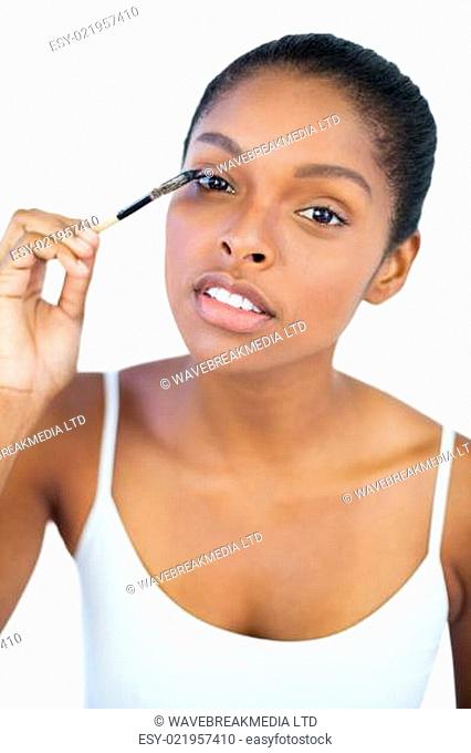 Dark haired woman putting on mascara