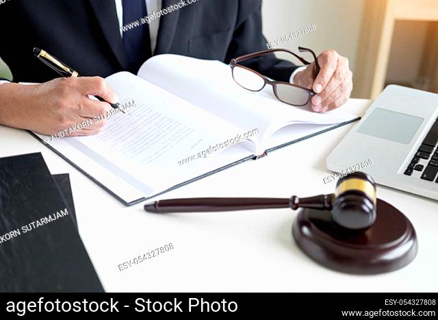 lawyer hand writes the document in court (justice, law) with sounding block