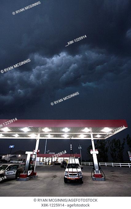 A Project Vortex 2 storm chaser waits out a squall line beneath a gas station awning in Nebraska, May 24, 2010