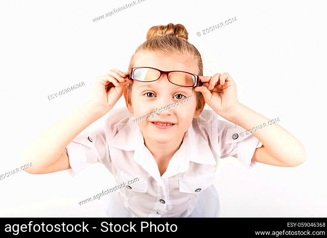 Closeup portrait of little girl wearing eyeglasses imitates a strict teacher against white background. Little student Looking at camera