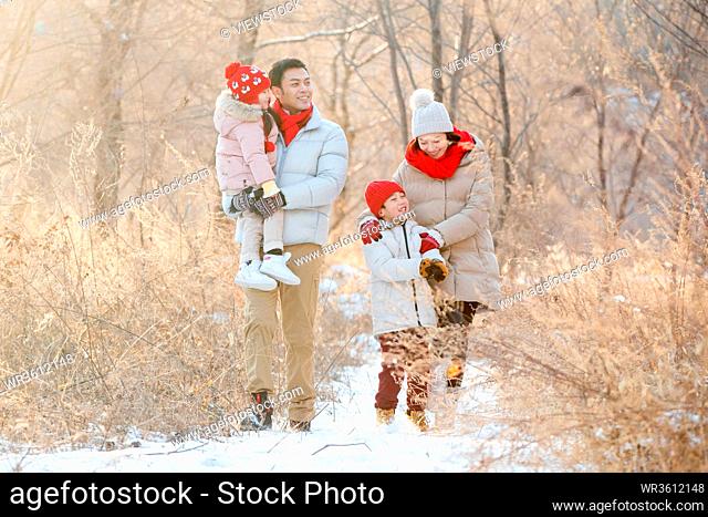 Happy family to go for a walk in the snow