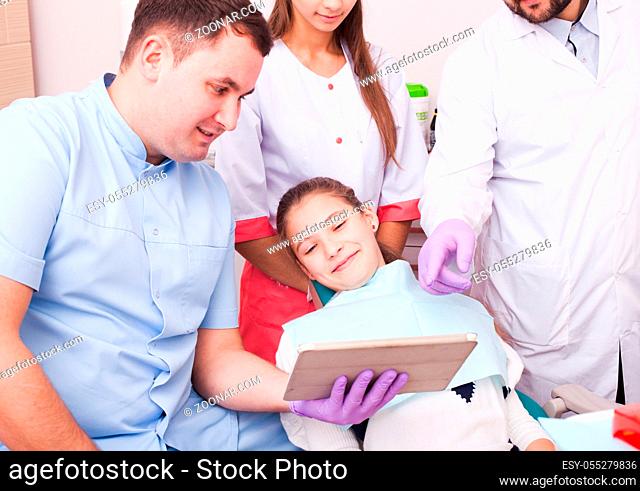 Teenage girl at the dental clinic, team of doctor discuss the situation