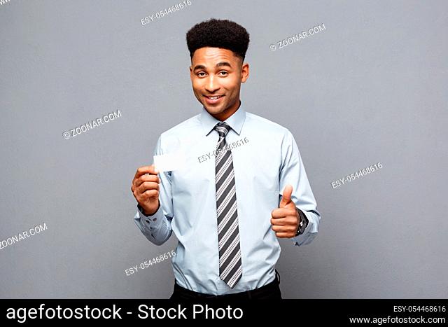 Business Concept - Happy handsome professional african american businessman showing name card to client