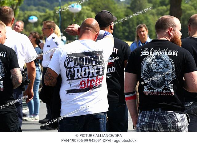 05 July 2019, Thuringia, Themar: Visitors stand in front of the event area at the Rechtsrock-Festival. The event was registered as a political rally - according...