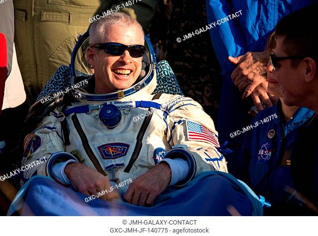 Expedition 40 Commander Steve Swanson of NASA rests in a chair outside the Soyuz capsule just minutes after he and Flight Engineers Alexander Skvortsov and Oleg...