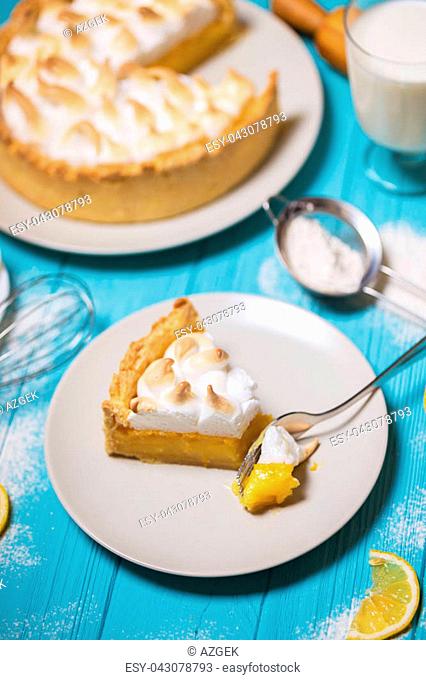 cooking dessert - delicious lemon tarts and classic meringue topping on a blue background