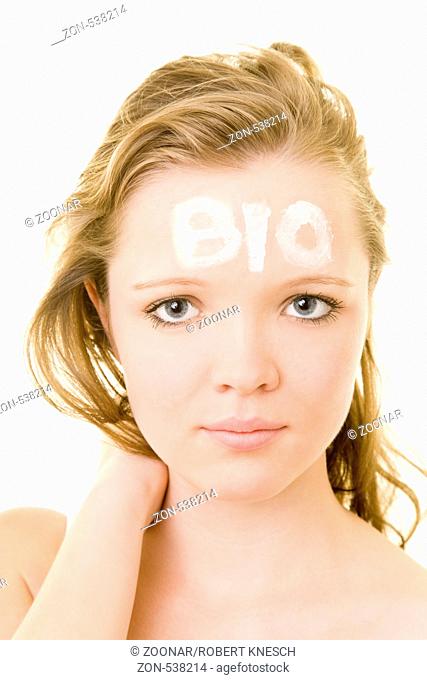 Blondes Mädchen mit dem Schriftzug Bio aus Creme auf der Stirn