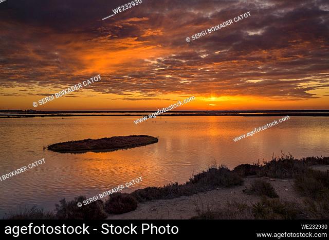 ENG: Red sunrise from a viewpoint in the lagoons of the Sant Antoni salt flats and the Món Natura Delta museum in the Ebro delta (Tarragona, Catalonia, Spain)