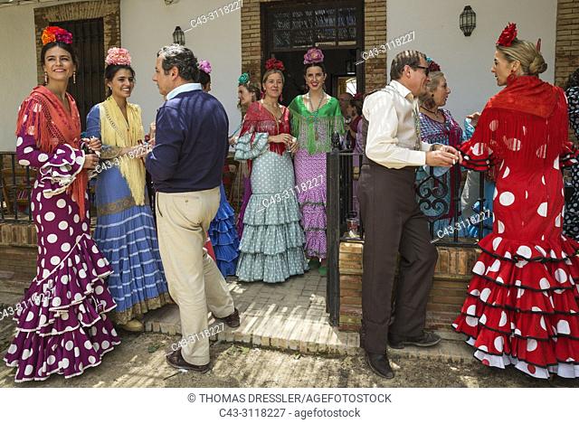 Women wearing beautifully coloured gypsy dresses and dressed up men during the annual Pentecost pilgrimage of El Rocio. Huelva province, Andalusia, Spain