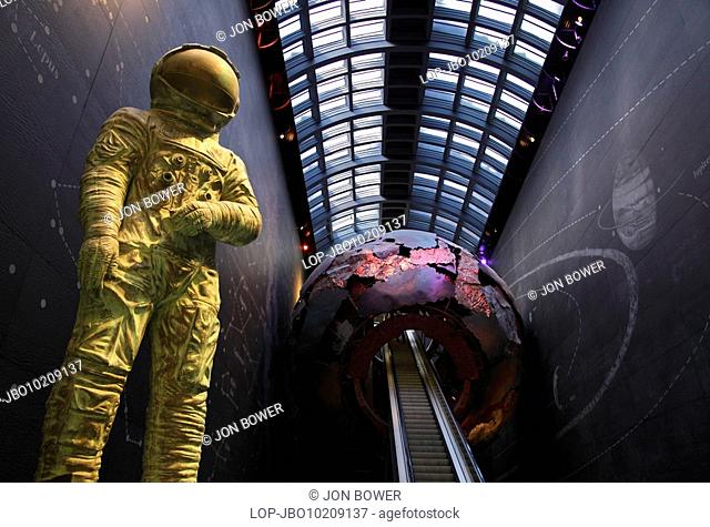 England, London, South Kensington, A sculpture of an astronaut by an escalator leading up into a giant earth sculpture in the Visions of Earth gallery in the...
