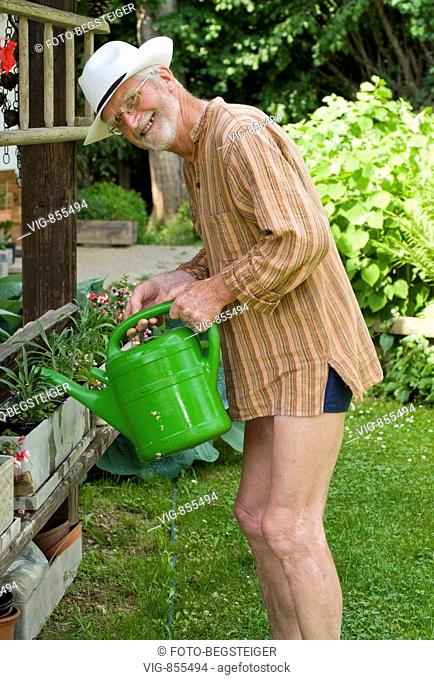 pensioner watering the flowers in garden. - 02/06/2008