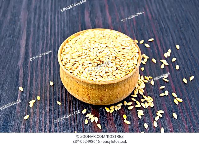 Linen seeds white in a bowl on a wooden plank background