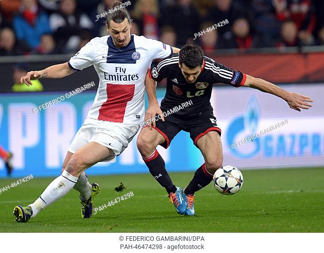 Leverkusen's Emir Spahic (R) and St. German's Zlatan Ibrahimovic vie for the ball during the Champions League last round of sixteen match between Bayer 04...