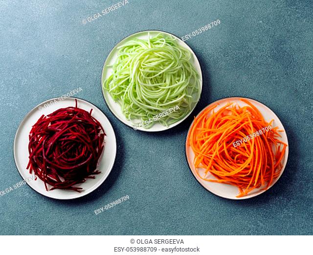 Vegetable noodles - zucchini, carrot, and beetroot noodles on plate over gray stone background. Clean eating, raw vegetarian, food concept