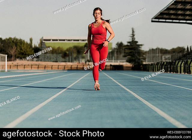 Sportswoman running on sports track at stadium