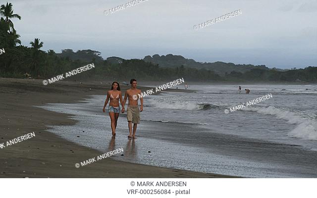 couple walking on the beach holding hands