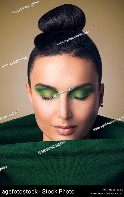 Beaitiful woman with green eye make-up looking down