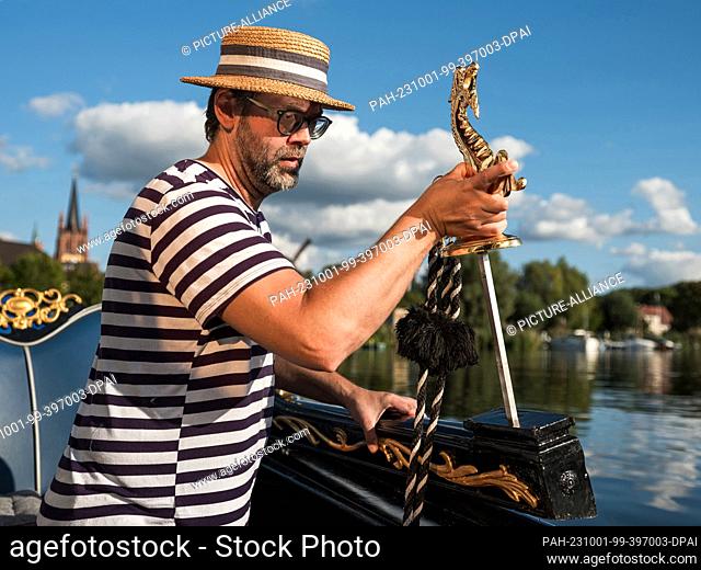 PRODUCTION - 25 September 2023, Brandenburg, Werder (Havel): Gondolier Alexander Fuchs mounts the gold-plated Venetian seahorses that are part of the...