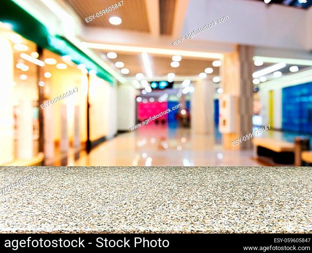 Marble board empty table in front of blurred background. Perspective marble table over blur in shopping mall hall. Mock up for display or montage your product