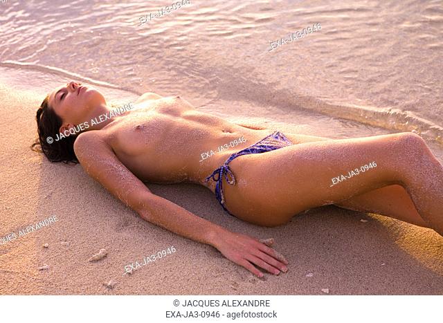 Semi-nude woman laying on beach