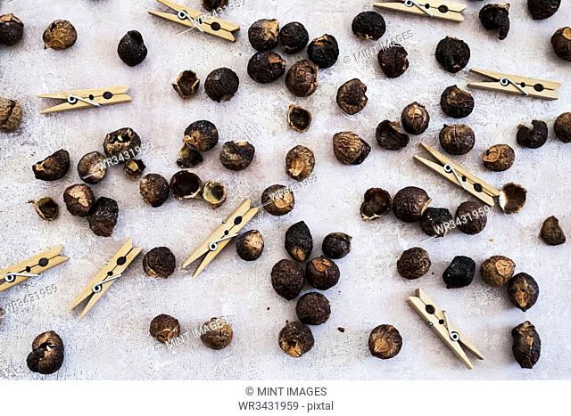 High angle close up of wooden clothes pegs and dried brown soap nuts