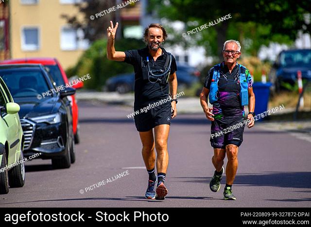 09 August 2022, Saxony-Anhalt, Magdeburg: Father Clemens (l) of the Premonstratensian Convent and Andreas Gierberg return from a marathon donation drive to...