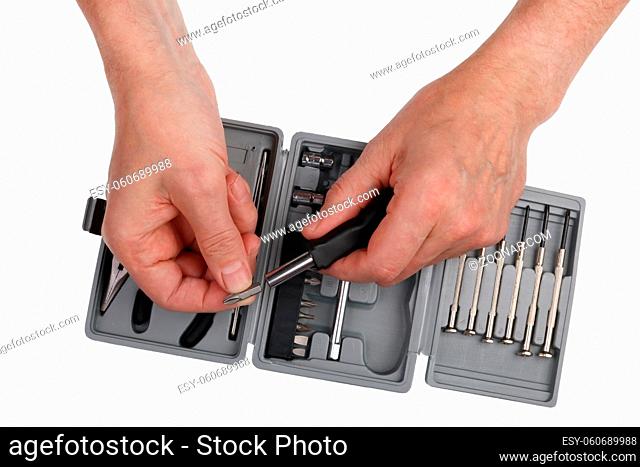 Home craftsman elderly man chooses a screwdriver from a set of tools. Isolated on white studio closeup shot