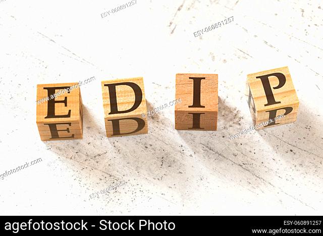 Four wooden cubes with letters EDIP meaning EXPLAIN DEMONSTRATE IMITATE PRACTICE on white working board.