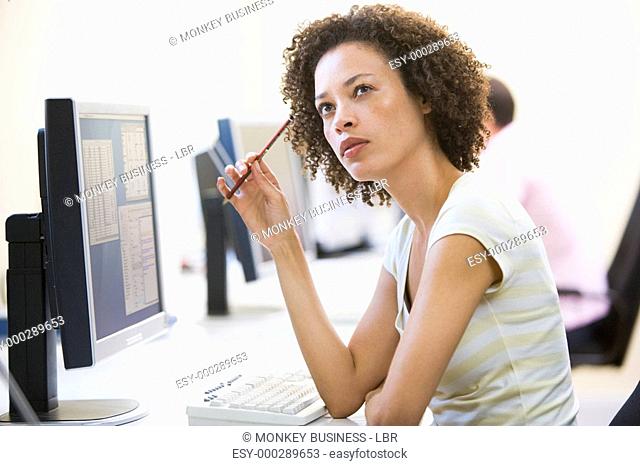 Woman in computer room thinking