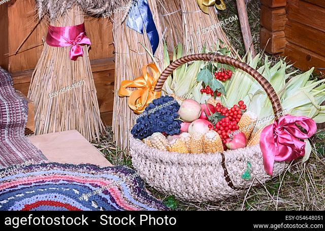 Large ripe apples , grapes, berries and vegetables are sold in beautifully decorated wicker basket at the fair