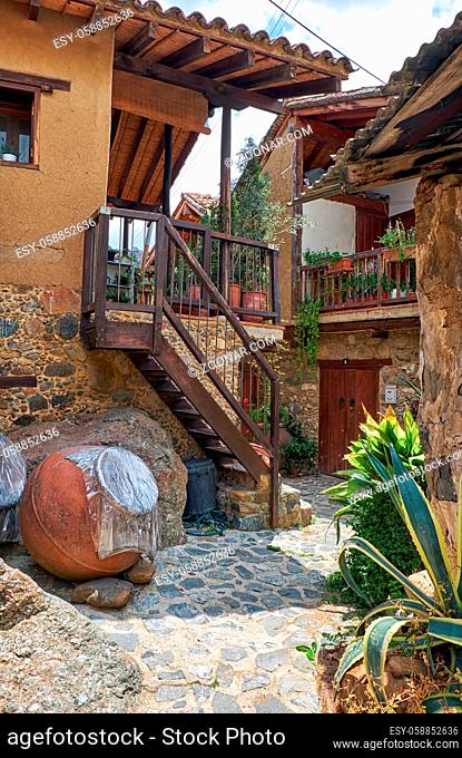 The old Kakopetria in the Troodos Mountains. The view of narrow stone paved street between traditional cozy houses with wooden balconies