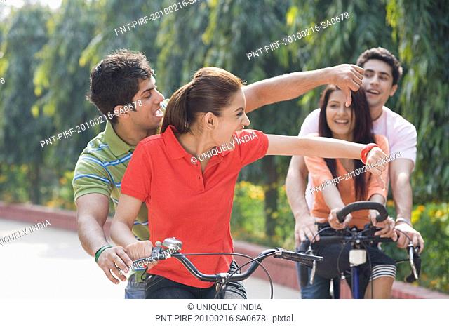 Two couples riding bicycles