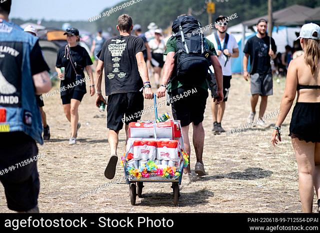 18 June 2022, Lower Saxony, Scheeßel: Two young men transport beer with a handcart to the Hurricane Festival campground. The open-air festival with around 78