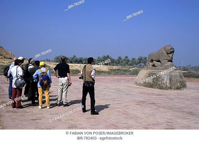 Tourist group looking at the famous lion statue in Babylon, Iraq, Middle East