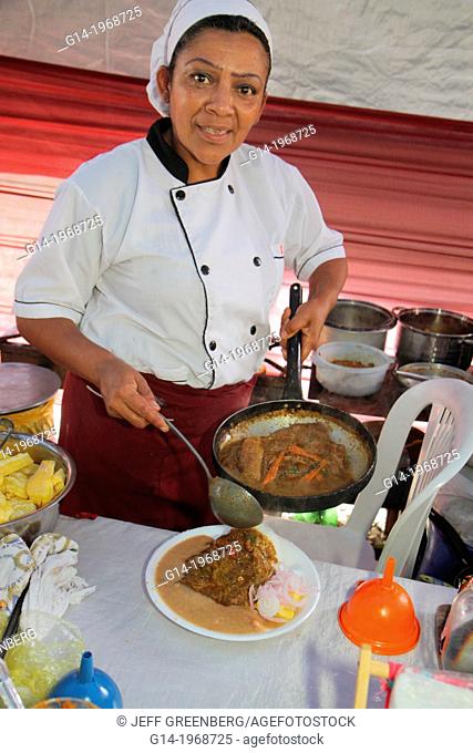 Peru, Lima, Barranco District, Calle Colon, neighborhood, community fund-raiser, food festival, dining, socializing, Hispanic, Black, woman, server, chef hat
