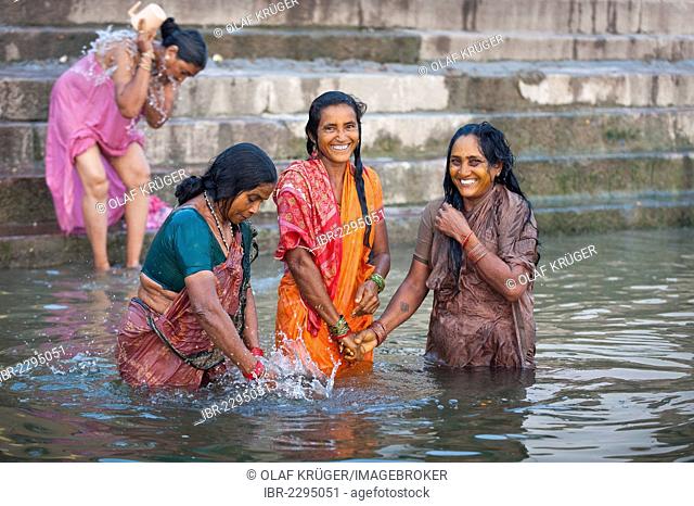 Smiling women taking a bath in the Ganges, Ghats, Varanasi, Benares or Kashi, Uttar Pradesh, India, Asia