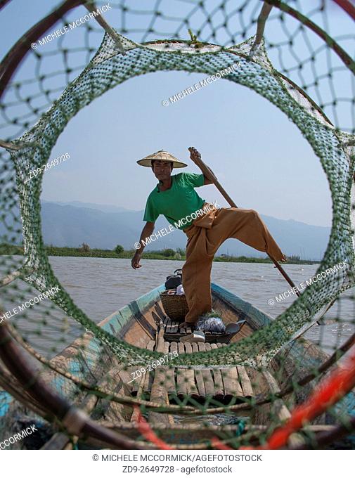 A fisherman poses for tourists on Inle Lake