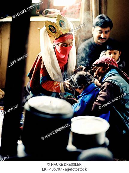 Oracle of Sabu, 77 year old healer Sonam Sangmu is treating a child in her kitchen near Leh, Ladakh, Jammu and Kashmir, India