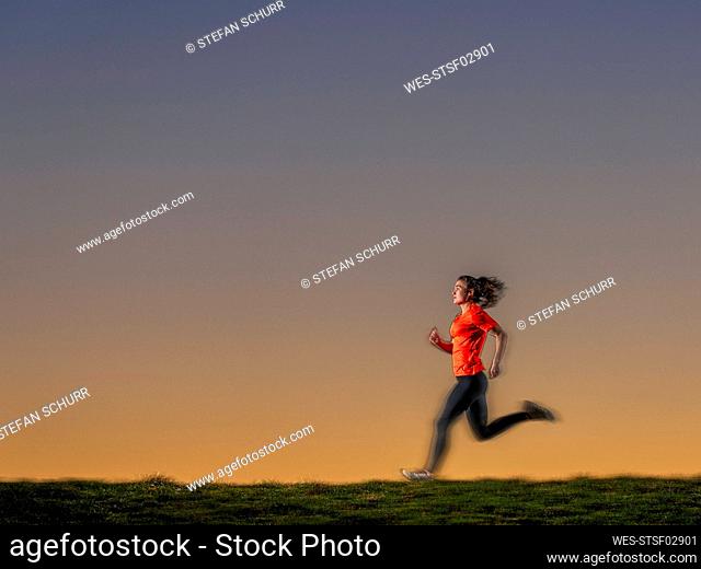 Sportswoman jogging during sunset